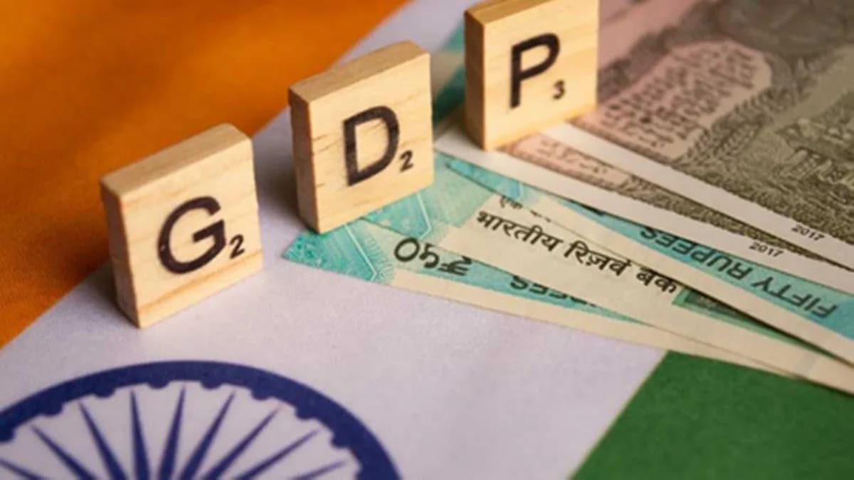 Wooden letter tiles spelling "GDP" on Indian rupee notes and the Indian flag.